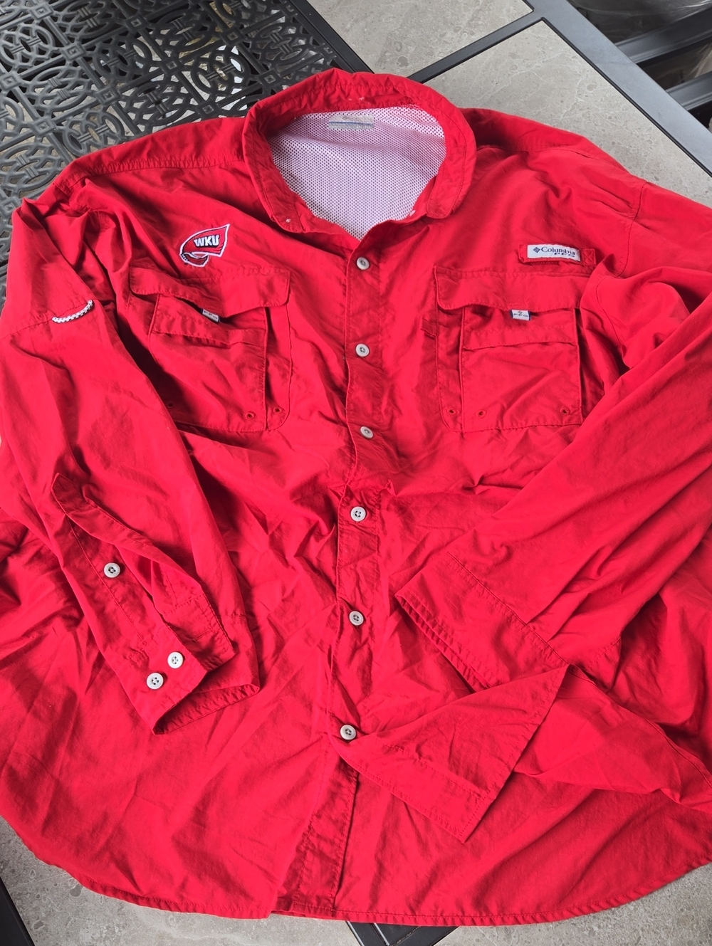 This Columbia PFG shirt in vibrant red features WKU branding and buttoned chest